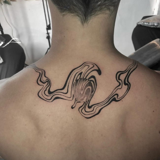 Black ink abstract wave tattoo on upper back.