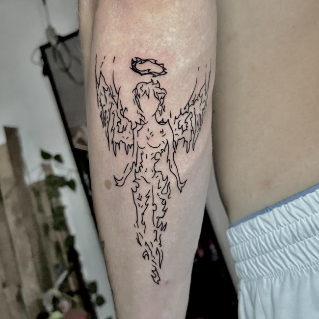 Black ink angel tattoo with halo on leg.